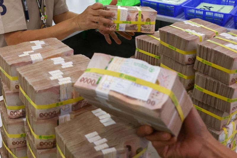 Bank employees gather Thai baht notes at a Kasikornbank in Bangkok on Jan 26, 2023. (Photo: Reuters)