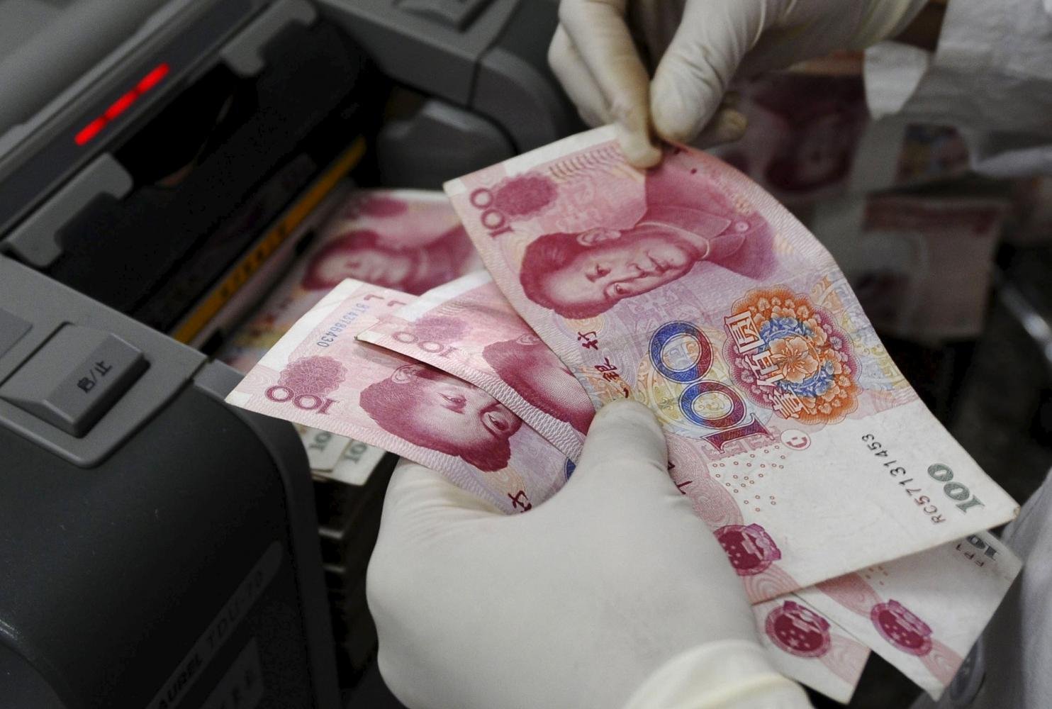 A staff member of a bank counts renminbi banknotes at a branch of the Bank of China in Changzhi, Shanxi province. (Photo: Reuters)
