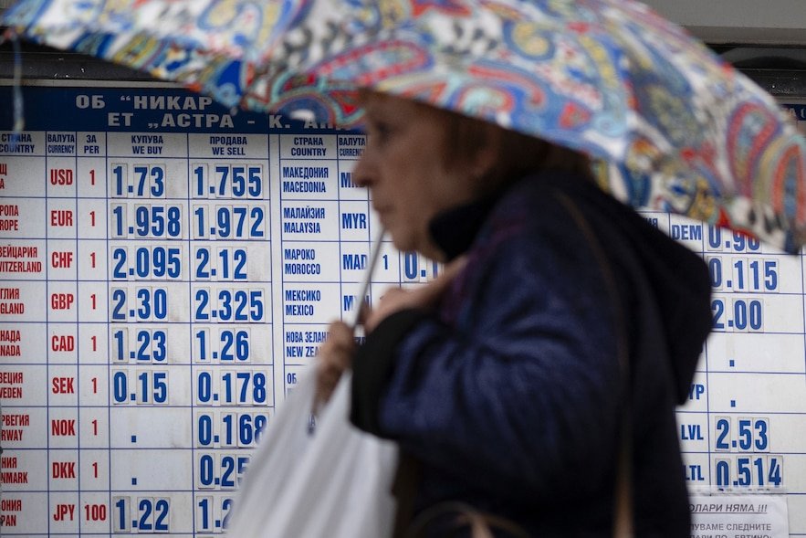 Une femme passe devant un bureau de change à Sofia, le 30 mai 2025 en Bulgarie