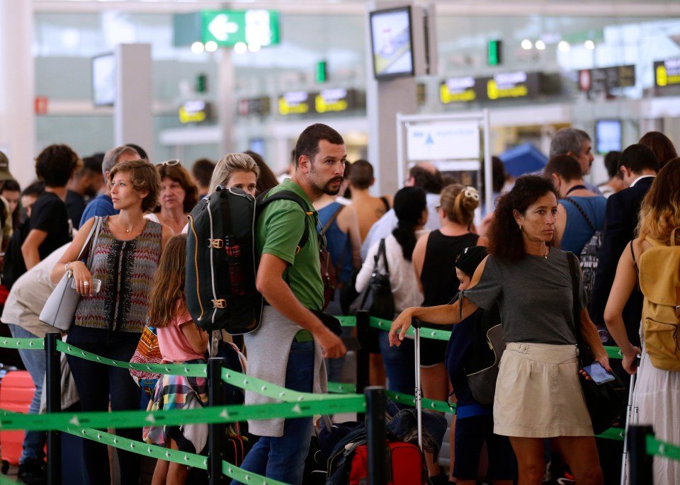 Passengers waiting in line at airport security.