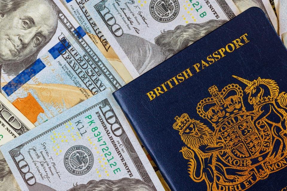 British passport on top of US hundred-dollar bills.