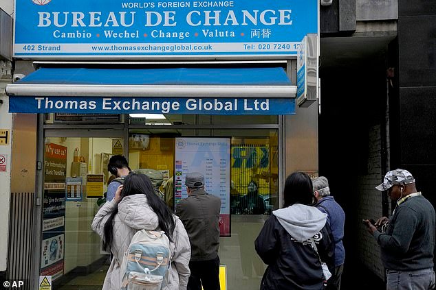People queue outside a bureau de change in London (file image). The pound has soared after strong UK economic growth cast fresh doubt over when interest rates will finally be cut