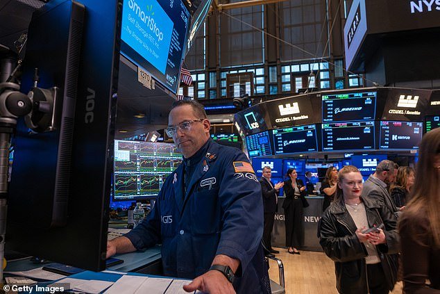 Traders work on the floor of the New York Stock Exchange before the Closing Bell yesterday