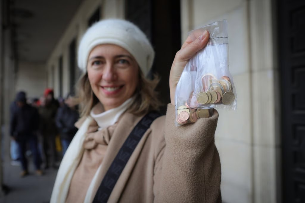 A woman holds euro coins. Photo: AP