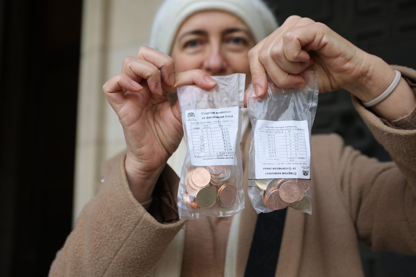 A woman poses as she holds new euro coins with Bulgarian symbols in Sofia